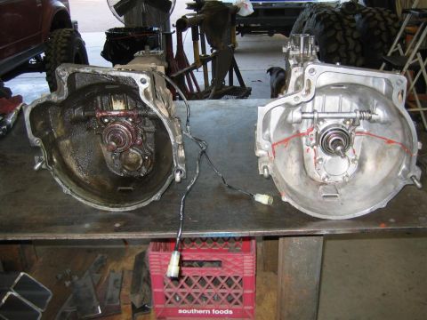 1987 Suzuki Samurai - Two transmissions are laid out on a workbench, one appearing used and the other recently cleaned.