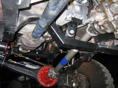 1987 Suzuki Samurai - Close-up of the undercarriage, focusing on the complex mechanical components of the vehicle's power transmission system.