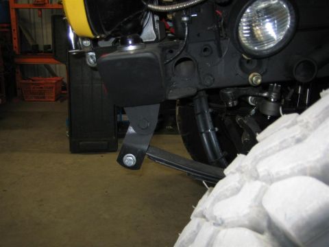 1987 Suzuki Samurai - Close-up of the front suspension system on a 1987 Suzuki Samurai, showing leaf springs and a large off-road tire.