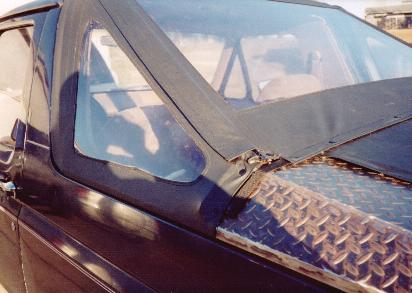 1990 Ford Bronco - Detail of the soft top attachment and diamond plate on the hood of a 1990 Ford Bronco.