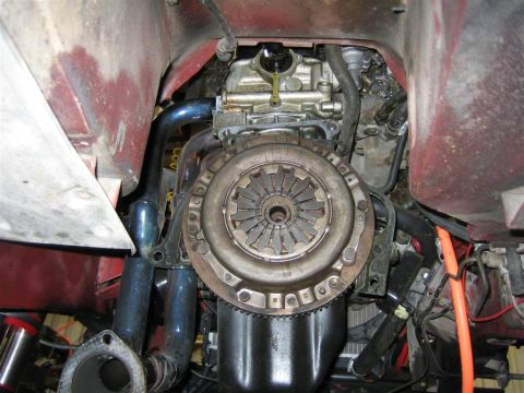 1987 Suzuki Samurai - Close-up view of a vehicle's engine and clutch assembly, showing exhaust piping and mechanical components.