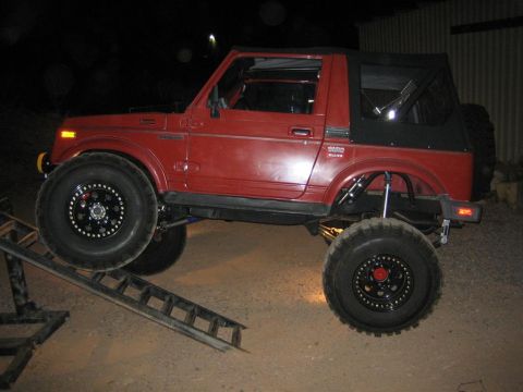 1987 Suzuki Samurai - This 1987 Suzuki Samurai is shown with a lifted suspension, large off-road tires, and a soft top, positioned on a ramp for a flex test.