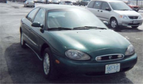 1999 Mercury Sable - Front view of a 1999 Mercury Sable sedan in a parking lot with other vehicles.