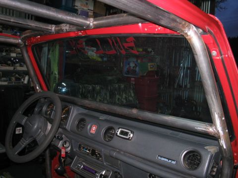 1987 Suzuki Samurai - The interior of a 1987 Suzuki Samurai features a custom roll cage and a dashboard with a "Samurai" badge.