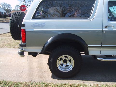 1994 Ford Bronco - This 1994 Ford Bronco is shown from the rear, a two-tone paint scheme and a spare tire mounted on the tailgate.