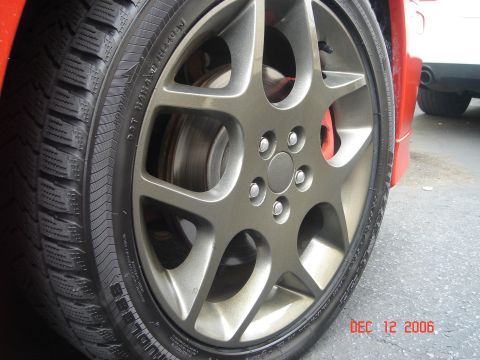 2005 Dodge SRT-4 - A close-up shot focuses on a car's wheel and tire, with a portion of another vehicle visible to the right.