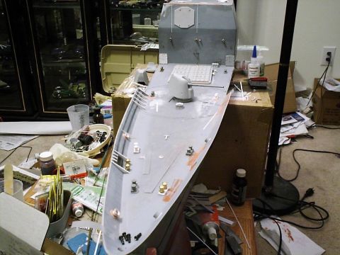 1998 Ford Crown Victoria - A partially assembled model ship sits on a table surrounded by paints, glues, and other modeling supplies.