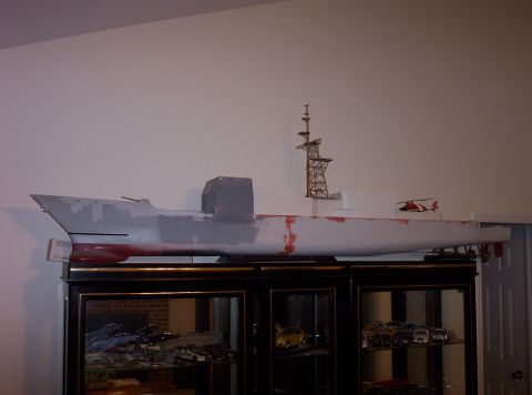 1998 Ford Crown Victoria - A model ship, possibly a destroyer, is displayed on a shelf above a glass-doored cabinet containing various model cars.