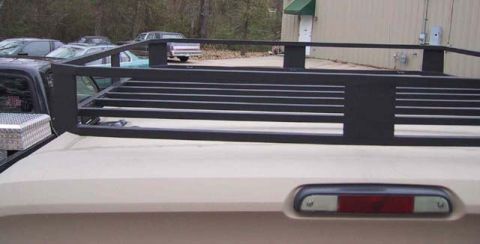 1995 Ford Bronco - A black roof rack is attached to the top of a tan vehicle.