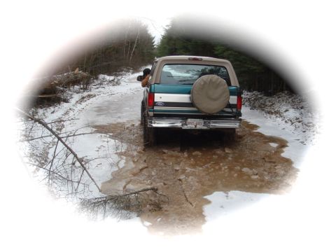 1996 Ford Bronco - This 1996 Ford Bronco navigates a challenging muddy and icy path in a wooded area.
