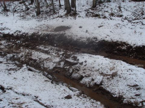 1996 Ford Bronco - A muddy and icy track winds through a snowy, wooded area.
