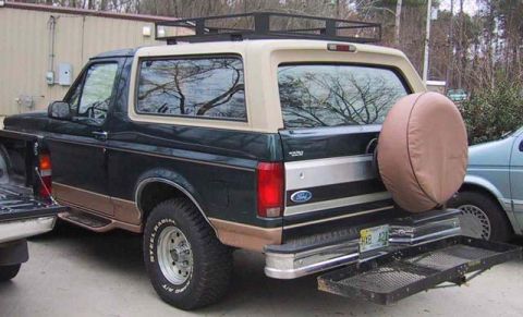 1995 Ford Bronco - This 1995 Ford Bronco features a roof rack and a rear-mounted spare tire carrier, along with a two-tone paint scheme.