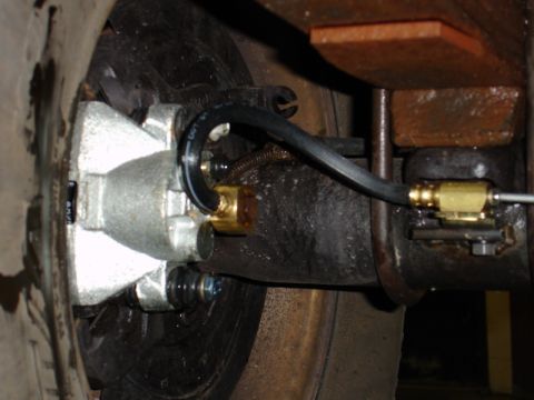 1996 Ford Bronco - A close-up view shows a brake caliper and hose assembly, with visible DOT 4 fluid marking on the hose.