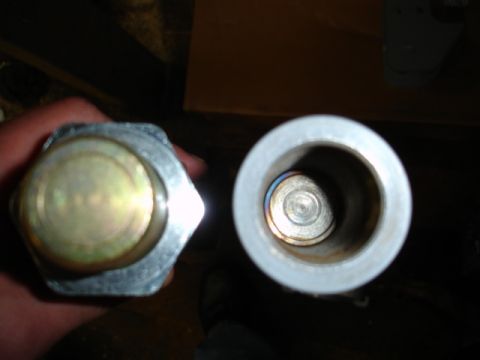 1996 Ford Bronco - Close-up of two metal cylindrical parts, one with a hexagonal head.