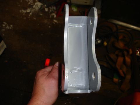 1996 Ford Bronco - A gray metal bracket, likely a vehicle part, is held up for inspection.