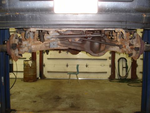 1996 Ford Bronco - The underside of a vehicle, showing the suspension and differential, is viewed while on a lift.