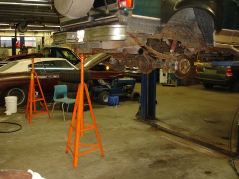 1996 Ford Bronco - Rear axle and suspension of a vehicle being worked on in a garage setting.