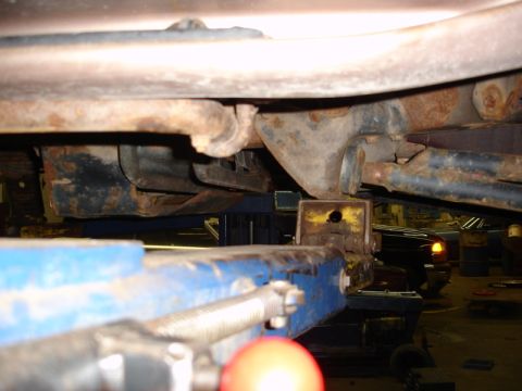 1996 Ford Bronco - The underside of a vehicle is shown while it is elevated on a repair lift.