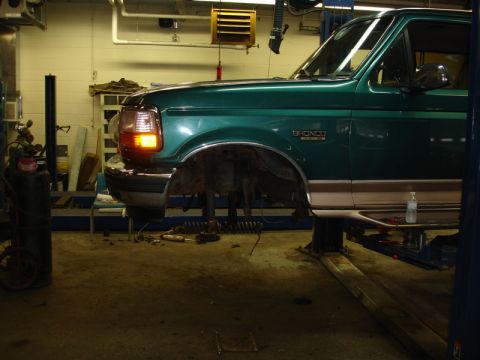 1996 Ford Bronco - 1996 Ford Bronco undergoing front suspension repair in a workshop.