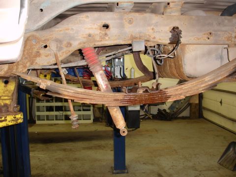 1996 Ford Bronco - Close-up view of the heavily rusted undercarriage of a vehicle, showing suspension components.