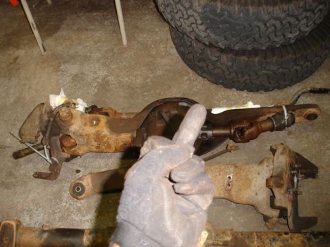 1996 Ford Bronco - Two heavily rusted vehicle axle assemblies are shown on a garage floor, with a gloved hand giving a thumbs up.