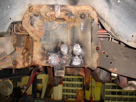 1996 Ford Bronco - Close-up view of a heavily corroded vehicle frame, showing evidence of recent welding repairs.