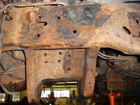 1996 Ford Bronco - Close-up view of a heavily corroded vehicle frame, showing extensive rust and structural damage.