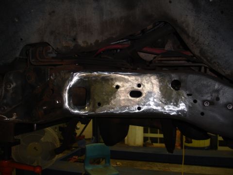 1996 Ford Bronco - A close-up view of a vehicle's frame shows a freshly repaired section with a bright metal patch.