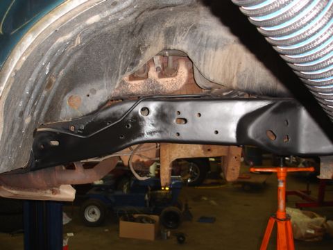 1996 Ford Bronco - Frame and suspension parts are visible in this close-up view, with a blue vehicle in the background.