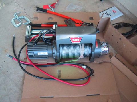 1995 Ford Bronco - A Warn winch and associated recovery gear are laid out on cardboard packaging.