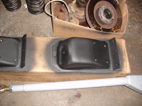 1996 Ford Bronco - Vehicle suspension components, including brackets and an adjustable control arm, are laid out on the floor.
