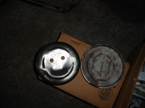 1996 Ford Bronco - Two metal discs, one with a smiley face design, are placed on a cardboard box.