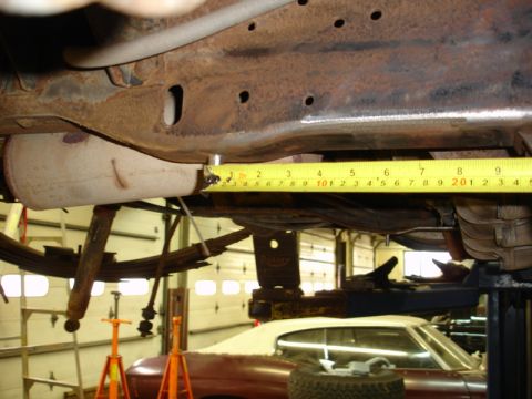 1996 Ford Bronco - A close-up view of a vehicle's rusty undercarriage, with a measuring tape in place.