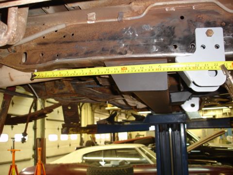 1996 Ford Bronco - A yellow measuring tape is placed along the rusty undercarriage of a vehicle, with new brackets installed.