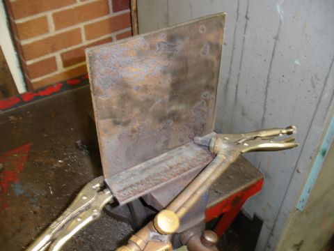 1996 Ford Bronco - A metal plate is secured by vise grips and a welding torch is positioned nearby.