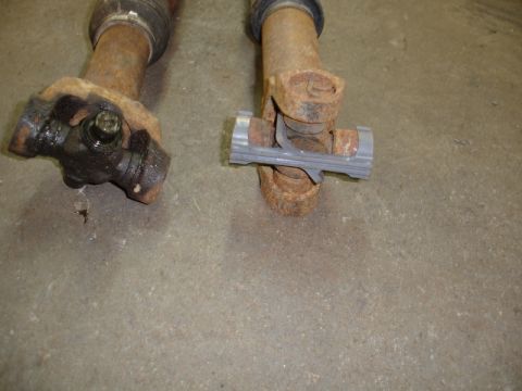 1996 Ford Bronco - Close-up of two worn driveshaft universal joints, showing rust and grease.
