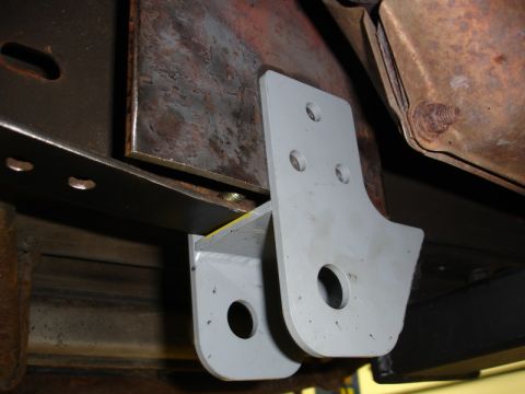 1996 Ford Bronco - Close-up of a gray metal bracket attached to a rusty vehicle frame, showing mounting holes.