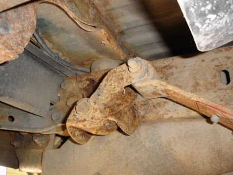 1996 Ford Bronco - The undercarriage of a vehicle shows significant rust on its frame and suspension components.