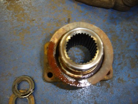 1996 Ford Bronco - A close-up view of a corroded automotive part with splined interior, resting on a textured blue surface.