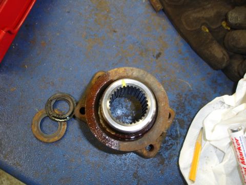 1996 Ford Bronco - Close-up of a rusty wheel bearing hub assembly with a yellow marker line.