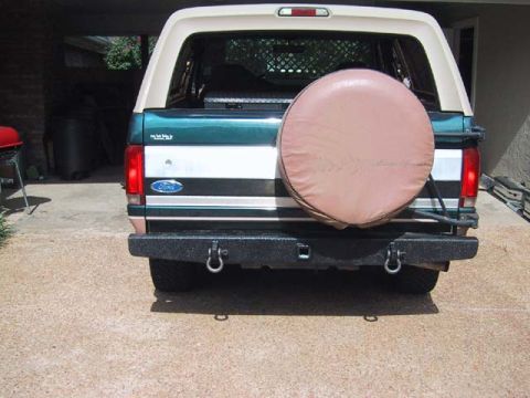 1995 Ford Bronco - The rear of a Ford Bronco is shown, a spare tire mounted on the back and a aftermarket bumper.