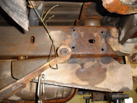1996 Ford Bronco - Close-up view of heavily rusted vehicle frame components, including suspension parts and exposed wiring.