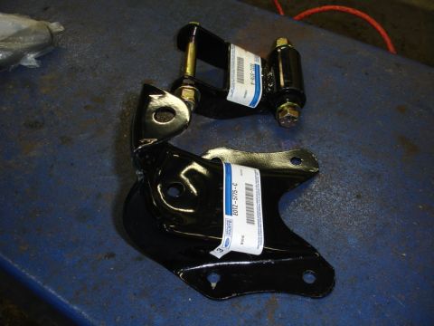 1996 Ford Bronco - New Ford suspension parts, possibly for a Bronco, sit on a blue surface.