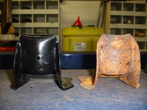 1996 Ford Bronco - Comparison of a new metal bracket with a severely corroded one, likely showing wear and tear over time.