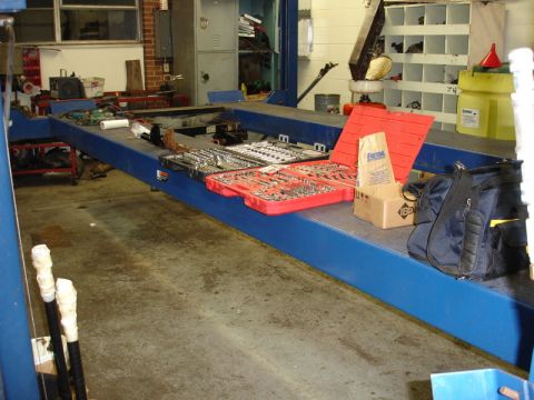 1996 Ford Bronco - A workshop scene with tools laid out on a car lift, suggesting repair or maintenance work.