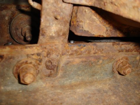 1996 Ford Bronco - Heavily rusted vehicle frame components and bolts are visible in this close-up shot.
