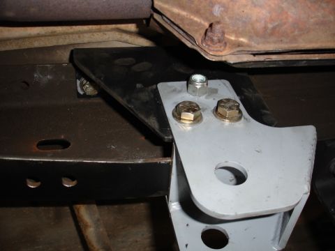1996 Ford Bronco - A close-up view of a vehicle's underbody shows a newly installed bracket secured with bolts and nuts.