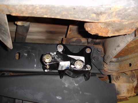 1996 Ford Bronco - Underside view of a vehicle frame with a newly installed part and visible rust.