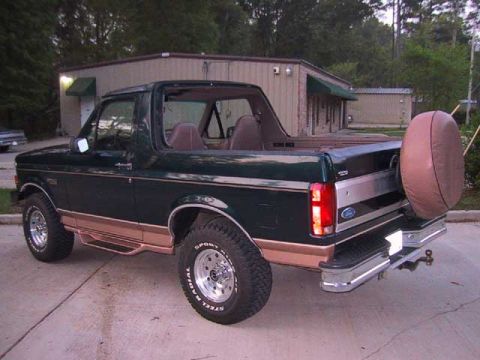 1995 Ford Bronco - This 1995 Ford Bronco features a dark green exterior with tan trim and a spare tire mounted on the rear.