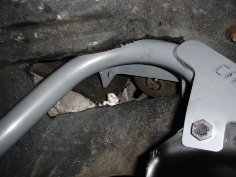 1996 Ford Bronco - A close-up view of a vehicle's undercarriage shows a gray metal bar attached to the frame, suggesting a modification or reinforcement.